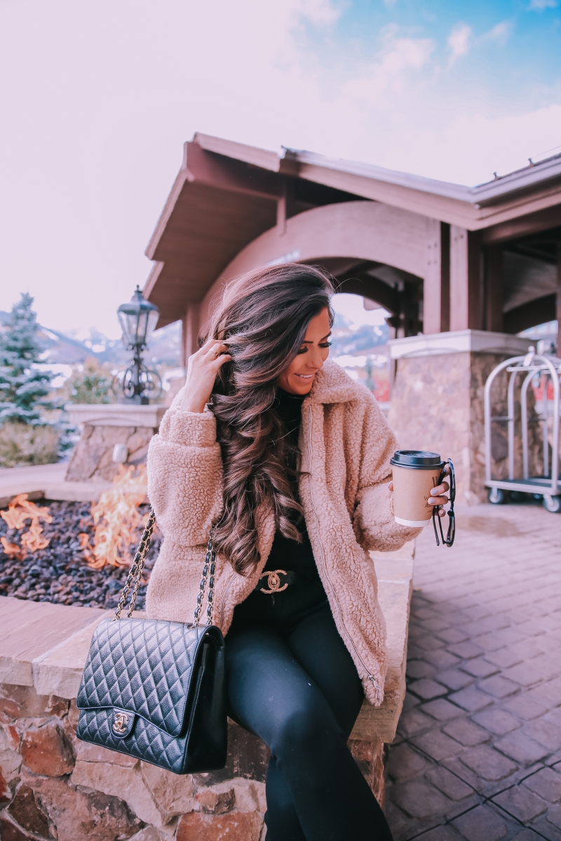 Fall fashion pinterest 2018, teddy bear coat outfit pinterest 2018, IAMGIA teddy coat, chanel belt outfit, park city travel fashion blogger, emily gemma blog, chanel classic black maxi-3 | I Am Gia Teddy Bear Jacket by popular US fashion blog, The Sweetest Thing: image of a woman standing outside next to a gas fire pit and wearing a Pixie Coat  I.AM.GIA brand: I.AM.GIA, H&M Ribbed Turtleneck Top, Nordstrom Florence Instasculpt Ankle Skinny Jeans DL1961, ShopBop Ash boots, H&M Large Earrings, Nordstrom Lip Cheat Lip Liner CHARLOTTE TILBURY, Chanel belt, Chanel purse, and Nordstrom MAC Matte Lipstick MAC COSMETICS.