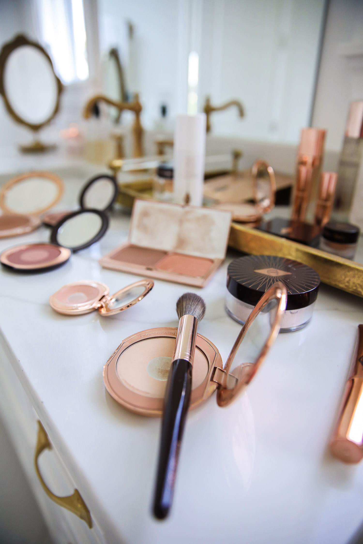 Charlotte tilbury magic cream light, charlotte tilbury makeup review, best charlotte tilbury makeup products, emily gemma-18 | Charlotte Tilbury Makeup by popular US beauty blog, The Sweetest Thing: image of a bathroom vanity covered with Charlotte Tilbury AIRBRUSH BRONZER TAN, Charlotte Tilbury HOT LIPS KIM K.W., Charlotte Tilbury MAGIC VANISH MEDIUM, Charlotte Tilbury CHEEK TO CHIC THE CLIMAX, Charlotte Tilbury NEW! LIGHTWEIGHT MOISTURISER MAGIC CREAM LIGHT 50 ML, Charlotte Tilbury BEAUTY LIGHT WAND PILLOW TALK MEDIUM, Charlotte Tilbury LUXURY PALETTE COPPER CHARGE, POWDER & SCULPT BRUSH ROSE GOLD & NIGHT CRIMSON, Charlotte Tilbury LEGENDARY LASHES VOLUME 2 BLACK VINYL, Charlotte Tilbury MAGIC NIGHT CREAM 50 ML, Charlotte Tilbury LIP CHEAT PILLOW TALK MEDIUM, Charlotte Tilbury CHARLOTTE'S GENIUS MAGIC POWDER 2 MEDIUM, Charlotte Tilbury FLAWLESS, PORELESS SKIN SECRETS FACE KIT, Charlotte Tilbury NEW! AIRBRUSH FLAWLESS SETTING SPRAY 100 ML, and Charlotte Tilbury INSTANT MAGIC FACIAL DRY SHEET MASK SINGLE MASK.