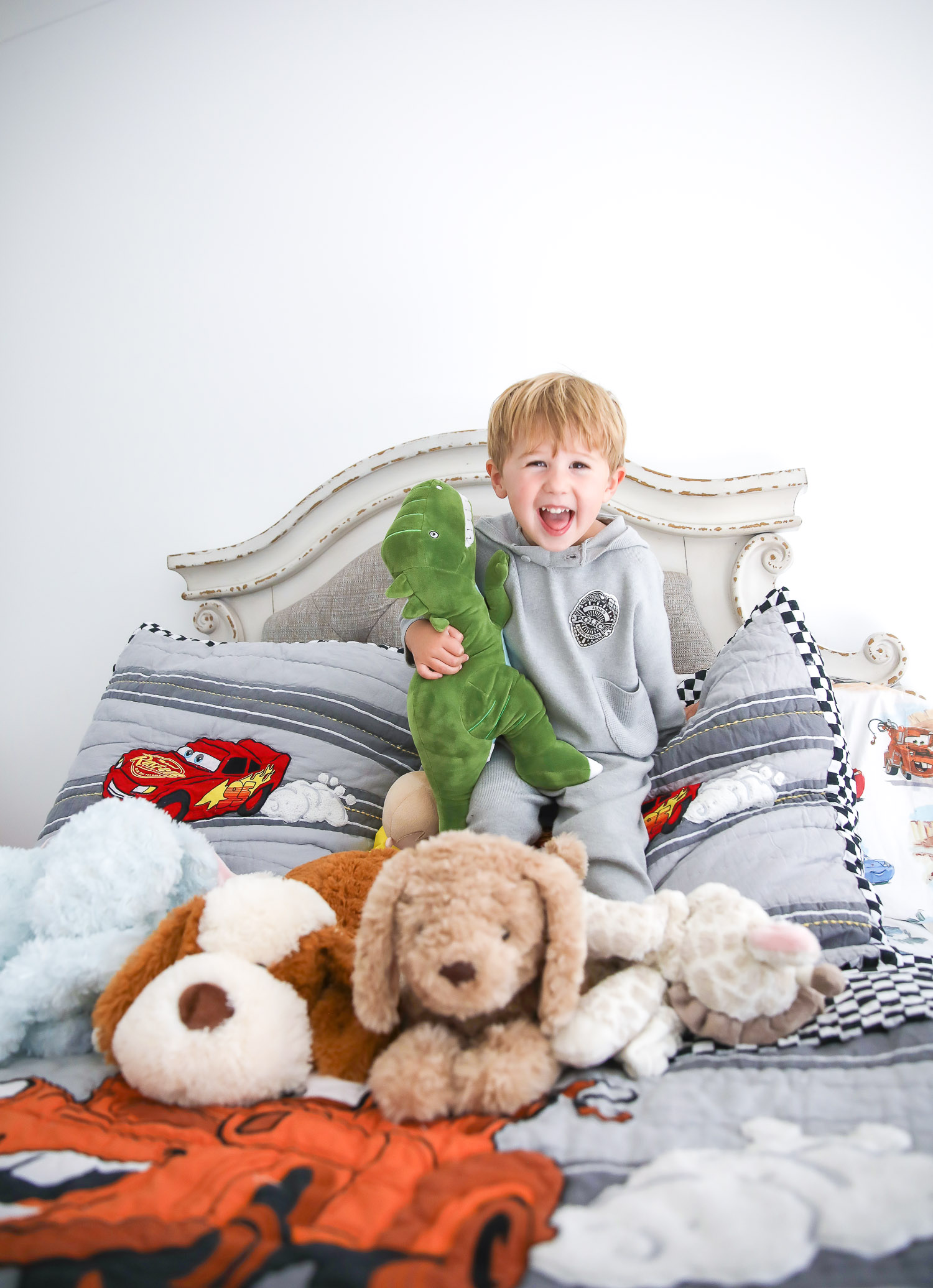 walmart kids home organization must haves, playroom organization ideas, emily gemma, the sweetest thing blog | Playroom Organization by popular US life and style blog, The Sweetest Thing: image of a little boy sitting on his bed with some stuffed animals.