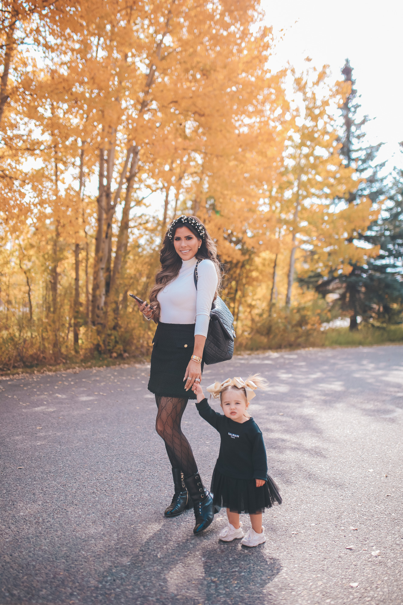 fall fashion pinterest outfits 2020, express fall fashion, emily gemma, baby girl fall outfits | Fall Clothing by popular US fashion blog, The Sweetest Thing: image of Emily Gemma walking outside and with her young daughter and wearing a Express Novelty Button Mock Neck Top, Express High Waisted A-Line Tweed Mini Skirt, Chanel boots, Gucci tights, Cartier bracelet and pearl knot headband. 
