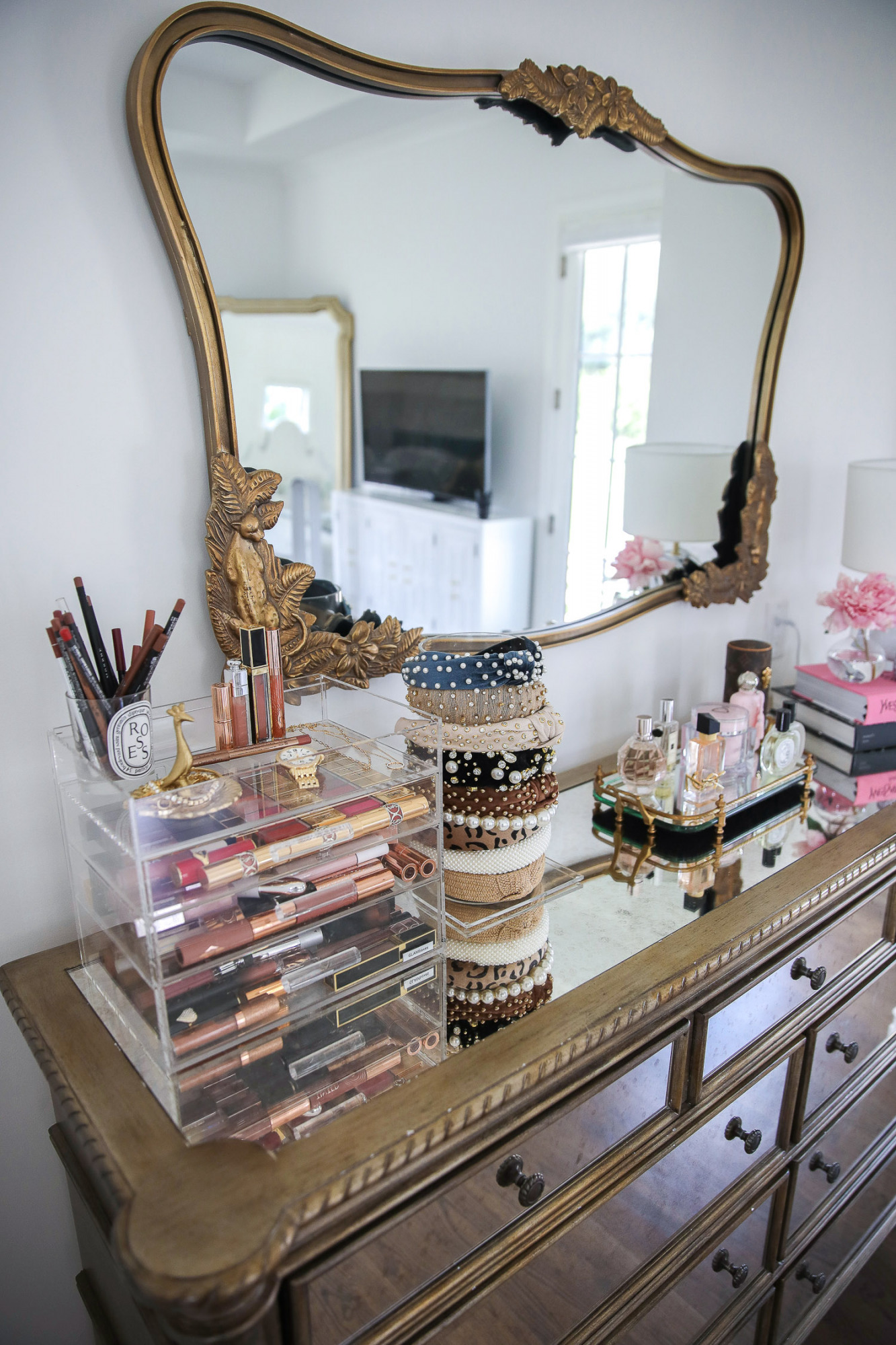 hooker furniture master bedroom, master bedroom Inspo interest, Emily Gemma master bedroom, Anthropologie mirrors, perfume trays, Pinterest home Inspo 2021 |  Nordstrom Anniversary Sale 2021 by popular US life and style blog, The Sweetest Thing: image of a master bedroom with a mirrored dresser set with a gold metal and mirrored tray with perfume bottles, headband organizer, fashion coffee table books, and acrylic makeup organizer filled with makeup. 
