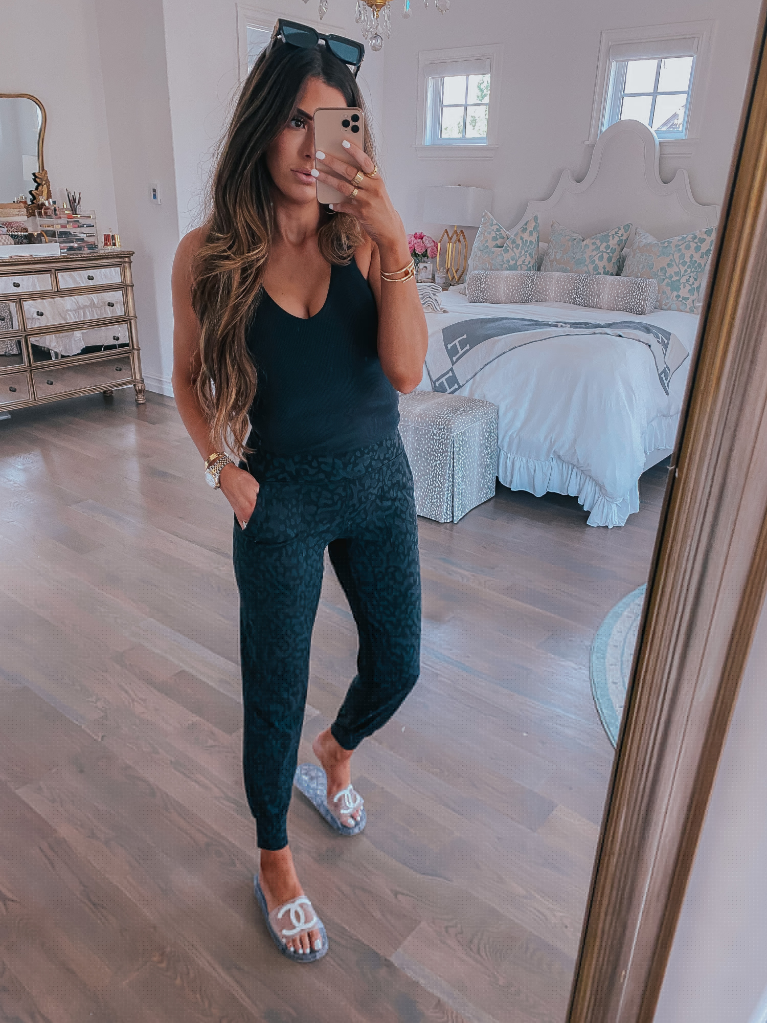 https://www.theswetestthingblog.com/wp-content/uploads/2021/07/Nsale-2021-must-haves-Nordstrom-Anniversary-Sale-2021-picks-emily-gemma-Nordstrom-sale-ALO-yoga-Nsale-2021 |  Nordstrom Anniversary Sale by popular US fashion blog, The Sweetest Thing: image of Emily Gemma wearing a black tank top, black square frame sunglasses, Chanel slide sandals, and black leopard print jogger pants.